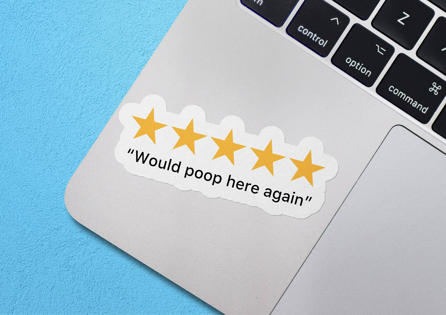 Sticker Bull 5 Stars Would Poop Here Again die cut vinyl sticker applied to a MacBook trackpad against a blue background — five golden stars above "Would poop here again" serif text