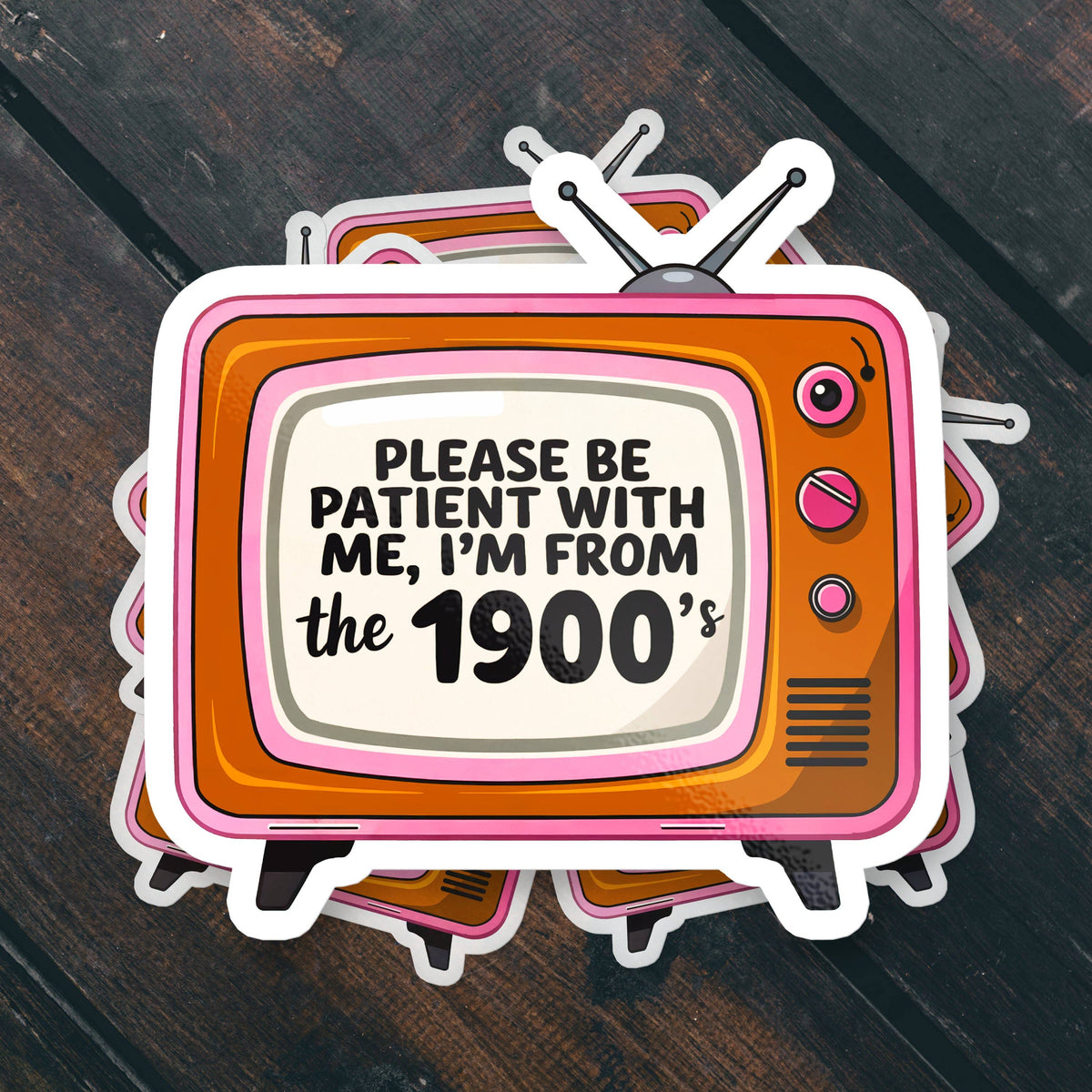 Stack of Sticker Bull Please Be Patient I'm From the 1900s die cut vinyl stickers fanned out on a dark diagonal wood surface — retro pink and orange tube TV with bold text on cream screen; white die cut border