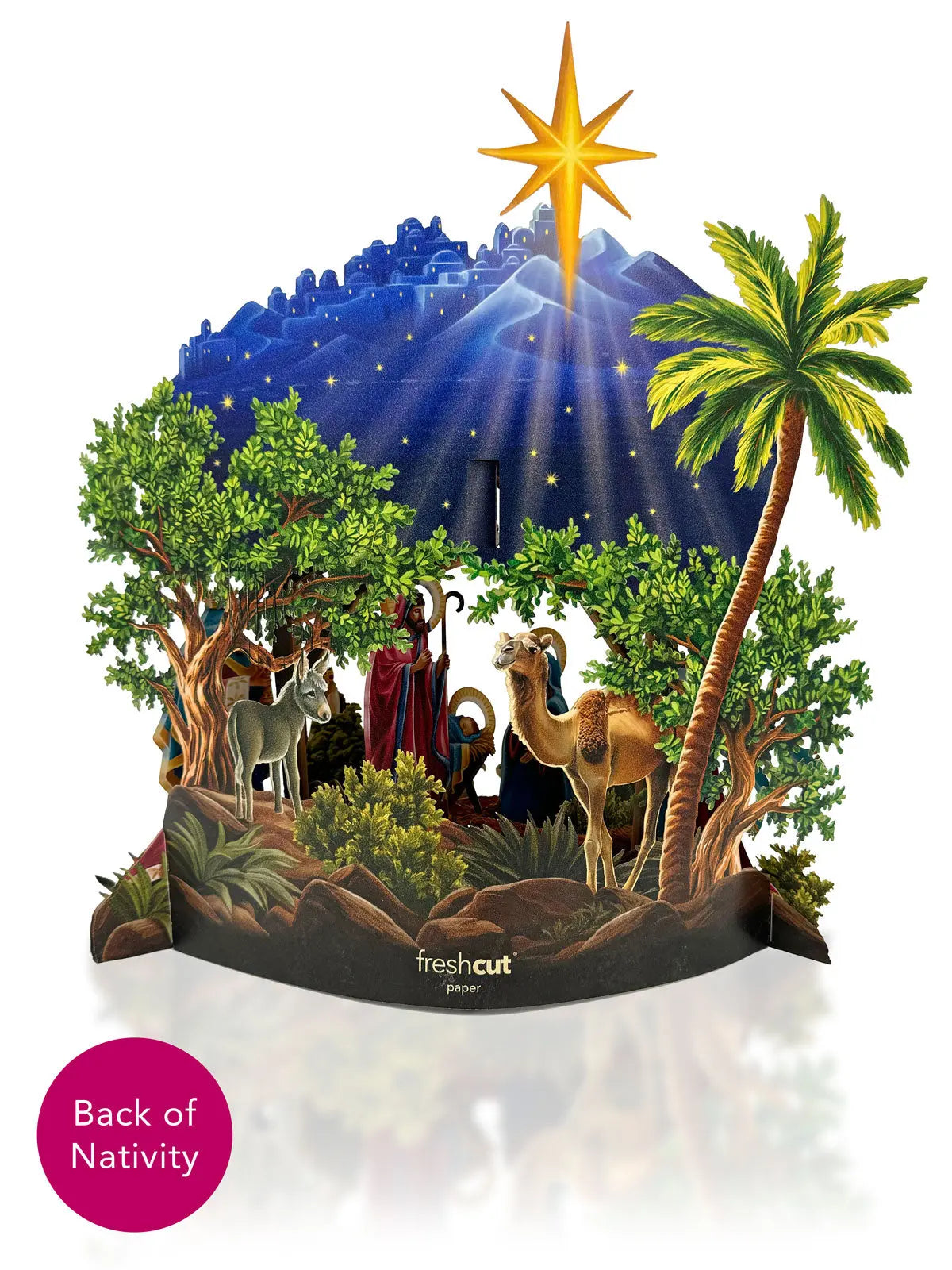 Back of Starlit Nativity pop-up on white background — reverse side showing lush green trees, donkey, camel, shepherd with staff, and Star of Bethlehem rays over deep blue Bethlehem skyline; FreshCut Paper logo on base banner