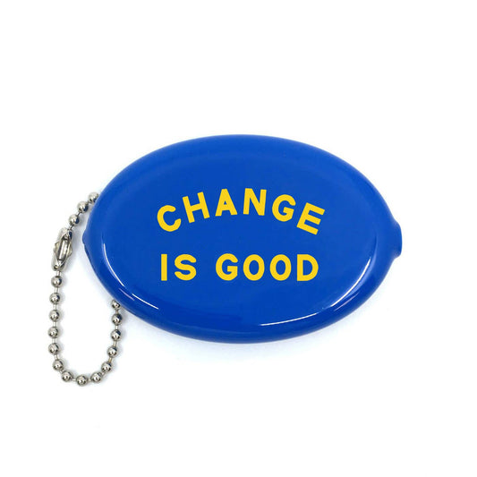 Three Potato Four Change Is Good rubber coin pouch on white background — oval glossy cobalt blue squeeze pouch with bold yellow arched "CHANGE IS GOOD" lettering across the face in two lines; silver ball chain with lobster clasp attached at left side
