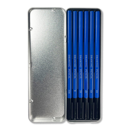 Open Elseware Unplug drawing pencils tin on white background — lid open to the left revealing silver interior; right side holds 6 blue-barreled graphite pencils labeled HB, B, 2B, 4B, 6B, and 8B arranged side by side with black tips facing down