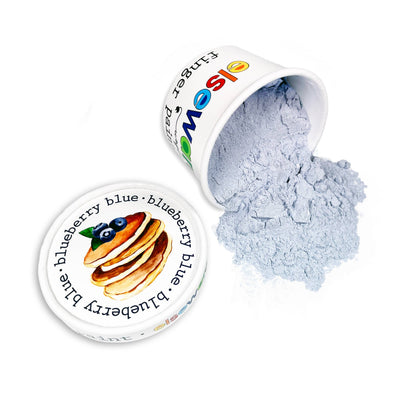 Elseware Unplug blueberry blue finger paint tub tipped on its side on white background with dry light blue powder spilling out — illustrated blueberry pancake lid beside the open tub; colorful Elseware Unplug logo visible on tub