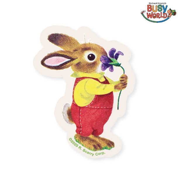 Die-cut vinyl sticker of Nicholas Bunny from Richard Scarry's I Am a Bunny on white background — illustrated brown bunny in red overalls and yellow shirt holding a purple iris flower; warm hand-painted illustration style with soft cream die-cut border following the character silhouette; ©2025 R. Scarry Corp. credit printed at bottom; Richard Scarry's Busy World logo in upper right corner