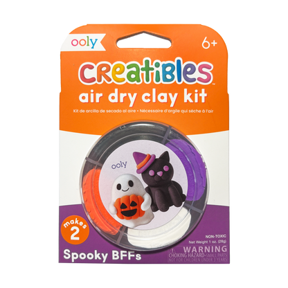 Front of OOLY Creatibles Air Dry Clay Kit — Spooky BFFs round tub packaging showing ghost and black cat with witch hat figurines on label — "makes 2," non-toxic, net weight 1 oz. (28g), ages 6+
