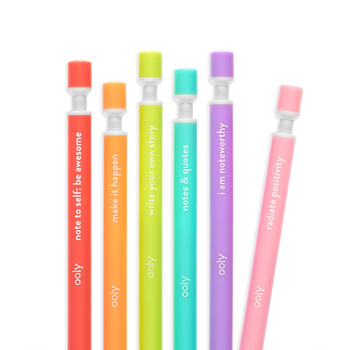 Close-up of the top ends of six OOLY Noted! mechanical pencils fanned out on a white background — pencils arranged diagonally from lower left to upper right showing the colored sharpener caps and quotes in white text: red "note to self: be awesome", orange "make it happen", lime "write your own story", teal "notes & quotes", purple "i am noteworthy", and pink "radiate positivity"; clear sharpener collar and ooly branding visible on each
