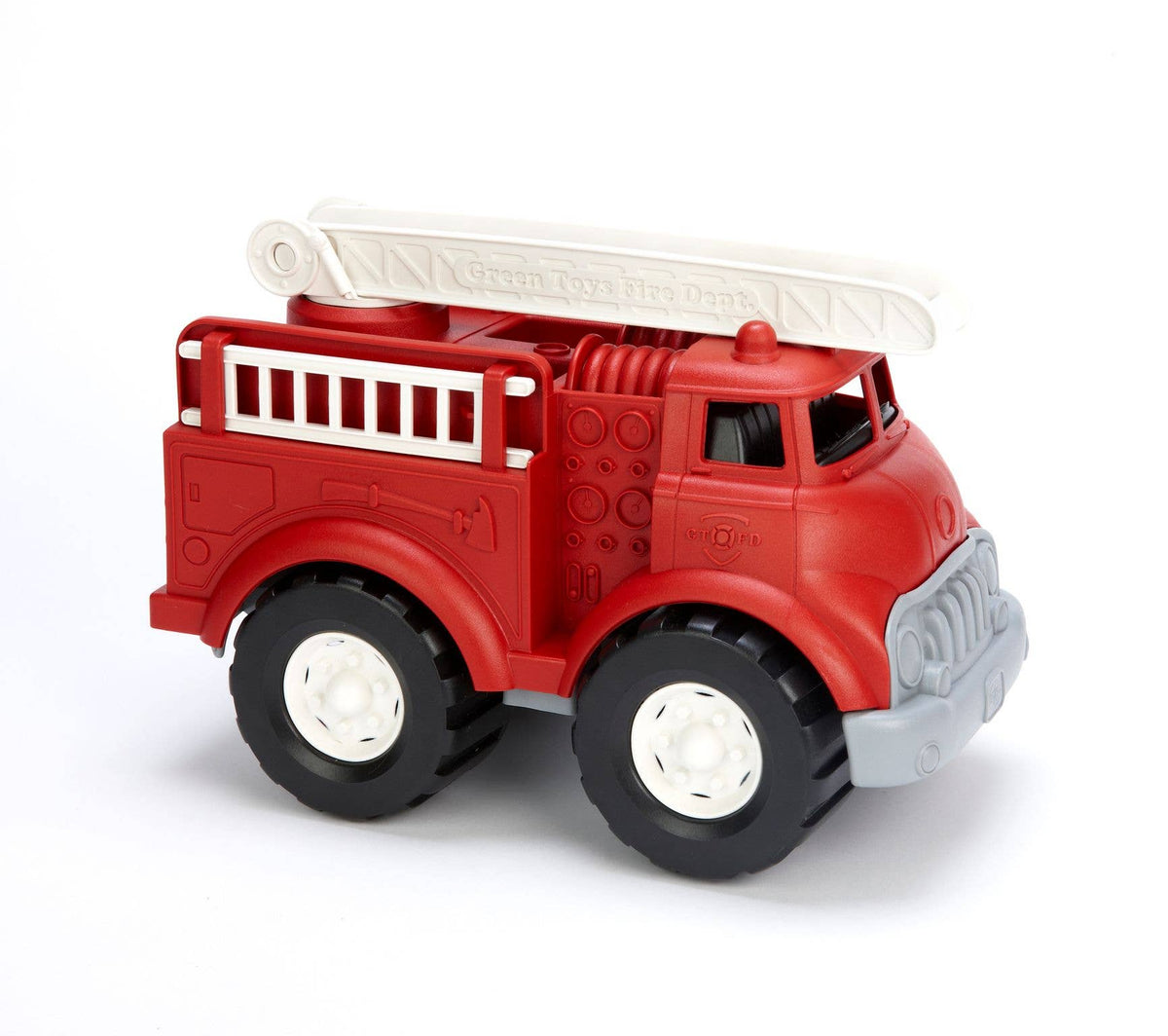 Green Toys Fire Truck in red on white background — chunky red plastic fire truck with grey front bumper and grille, black rubber wheels with white hubs, white articulating roof ladder extended diagonally, white side ladder panels along the truck body, red siren light on cab roof, and molded hose and equipment details on the side panels; Green Toys embossed text visible on the roof ladder