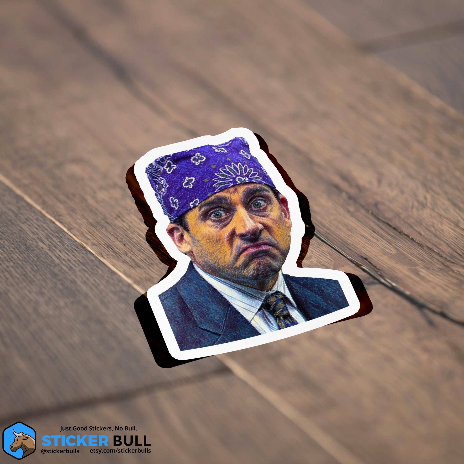 Sticker Bull Prison Mike The Office die cut vinyl sticker lying flat on a dark diagonal wood surface — illustrated Michael Scott as Prison Mike in purple bandana in navy suit; white die cut border; Sticker Bull logo in corner