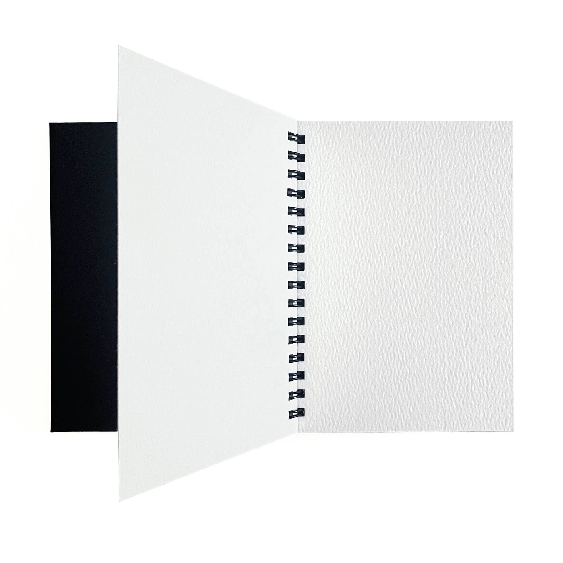 Elseware Unplug watercolor paper pad open flat on white background — black cover folded to the left; right side shows a blank white cold press watercolor paper page with visible cotton rag texture; black spiral binding visible in center