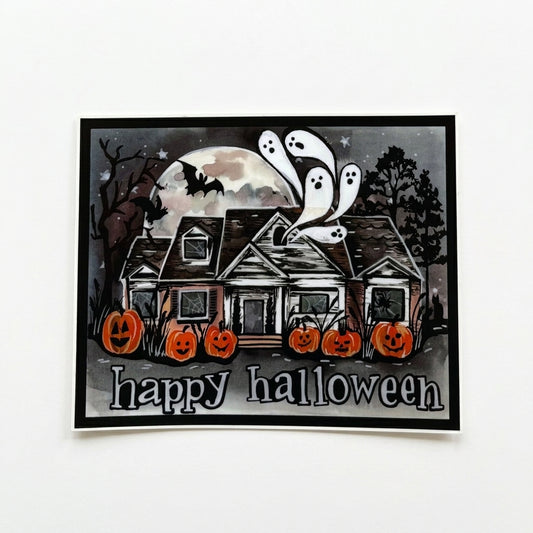 Happy Halloween vinyl sticker by Made By Shellie — rectangular matte sticker with black border; haunted house scene with five glowing jack-o-lanterns along the front, three white ghosts floating above the rooftop, a bat silhouetted against a large full moon, bare trees, and stars on a dark gray night sky; "happy halloween" in white hand-lettered text along the bottom; 4.75"×3.75"