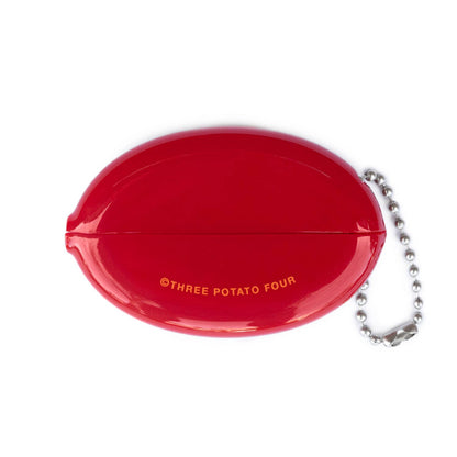 Back of Three Potato Four Pizza Money rubber coin pouch on white background — plain glossy red oval showing the horizontal squeeze seam line across the middle and "©THREE POTATO FOUR" printed in small orange text at lower center; silver ball chain attached at right