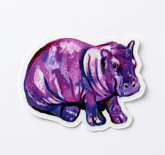Made by Shellie Purple Hippopotamus vinyl sticker — chunky baby hippo in rich purples, magentas, and blues in bold painterly watercolor style; die-cut with white border; light gray background