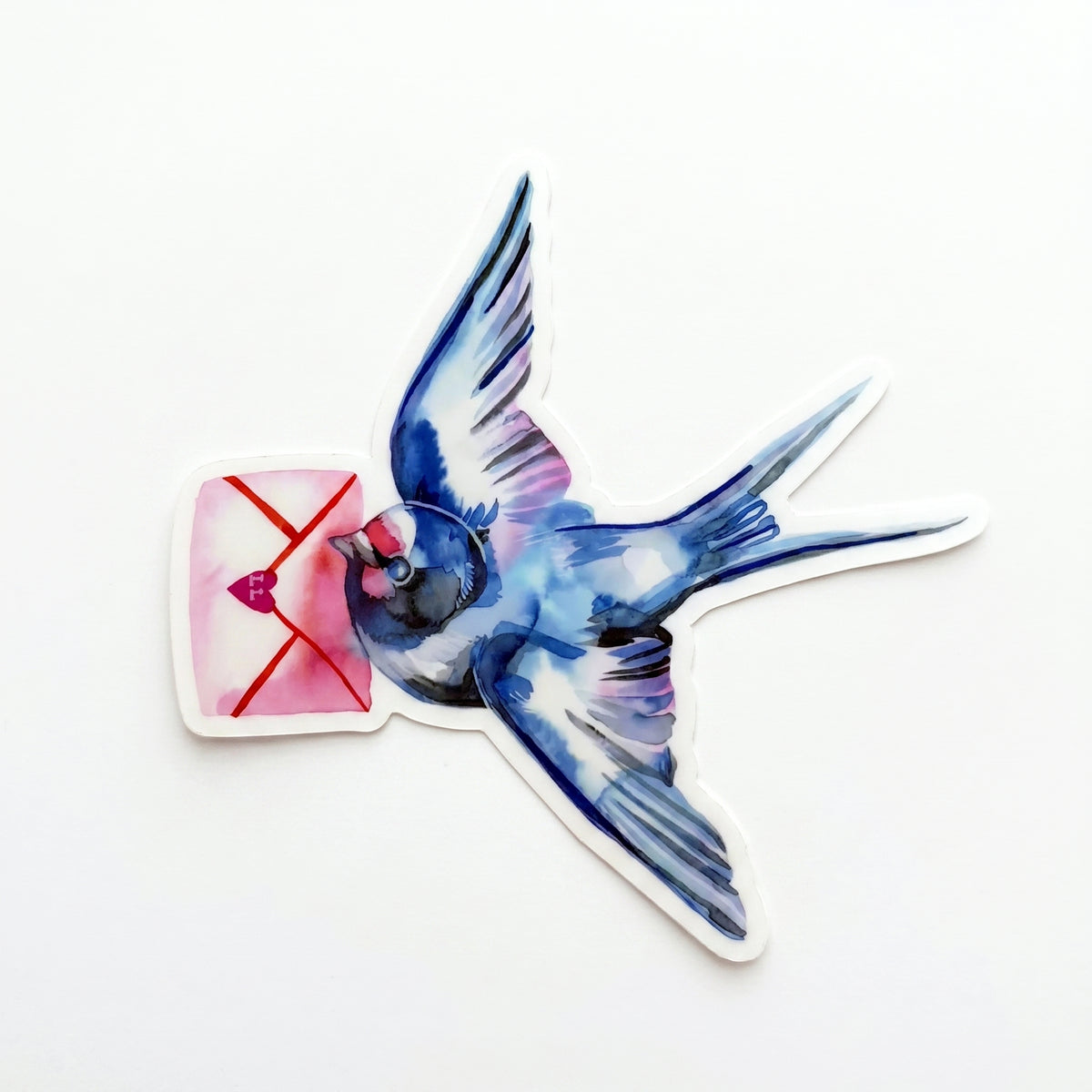 Made by Shellie Love Letter Bird vinyl sticker — watercolor swallow in deep blues and purples mid-flight carrying a pink envelope with red X and heart wax seal; die-cut with white border; white background