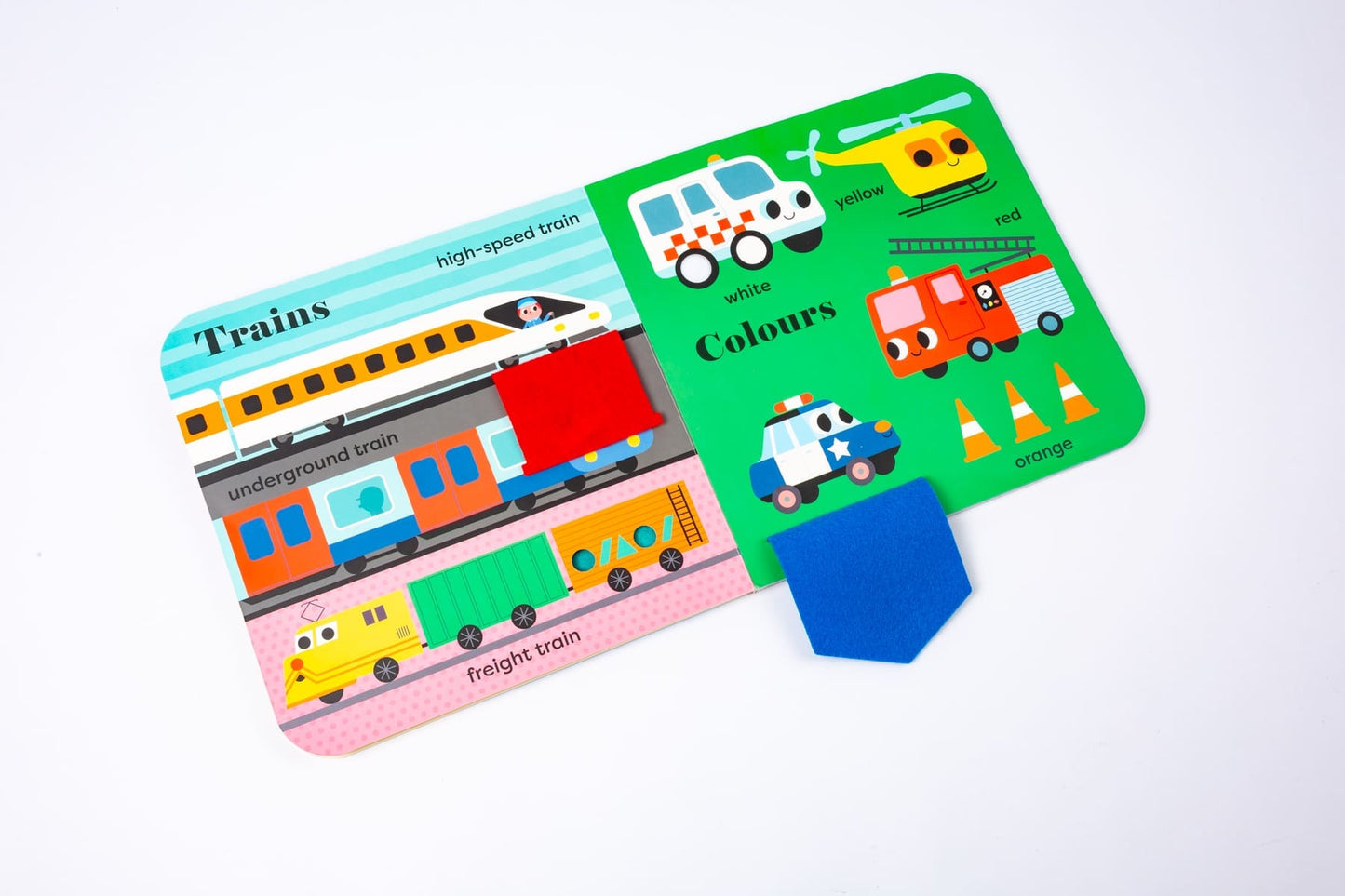My BIG Playbook: Things That Go open to the Trains page showing high-speed train, underground train, and freight train with a red felt flap, beside the Colours page with ambulance, yellow helicopter, red firetruck, orange cones, and police car with a blue felt flap, on a white background
