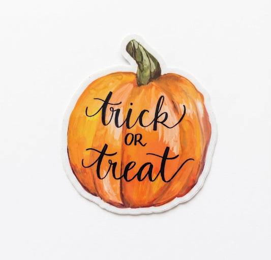 Trick or Treat Halloween Pumpkin vinyl sticker by Made By Shellie — die-cut sticker of a watercolor orange pumpkin with green stem; hand-lettered black script reads "trick or treat" across the front; white die-cut border; 3"×3.5"