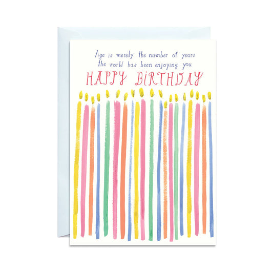 A white birthday card with colorful candles across the front. Above the candles reads,"Age is merely the number of years the world has been enjoying you."